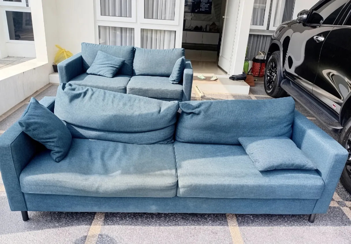 Sebelum dicuci: Sofa kain biru tampak pudar dan berdebu